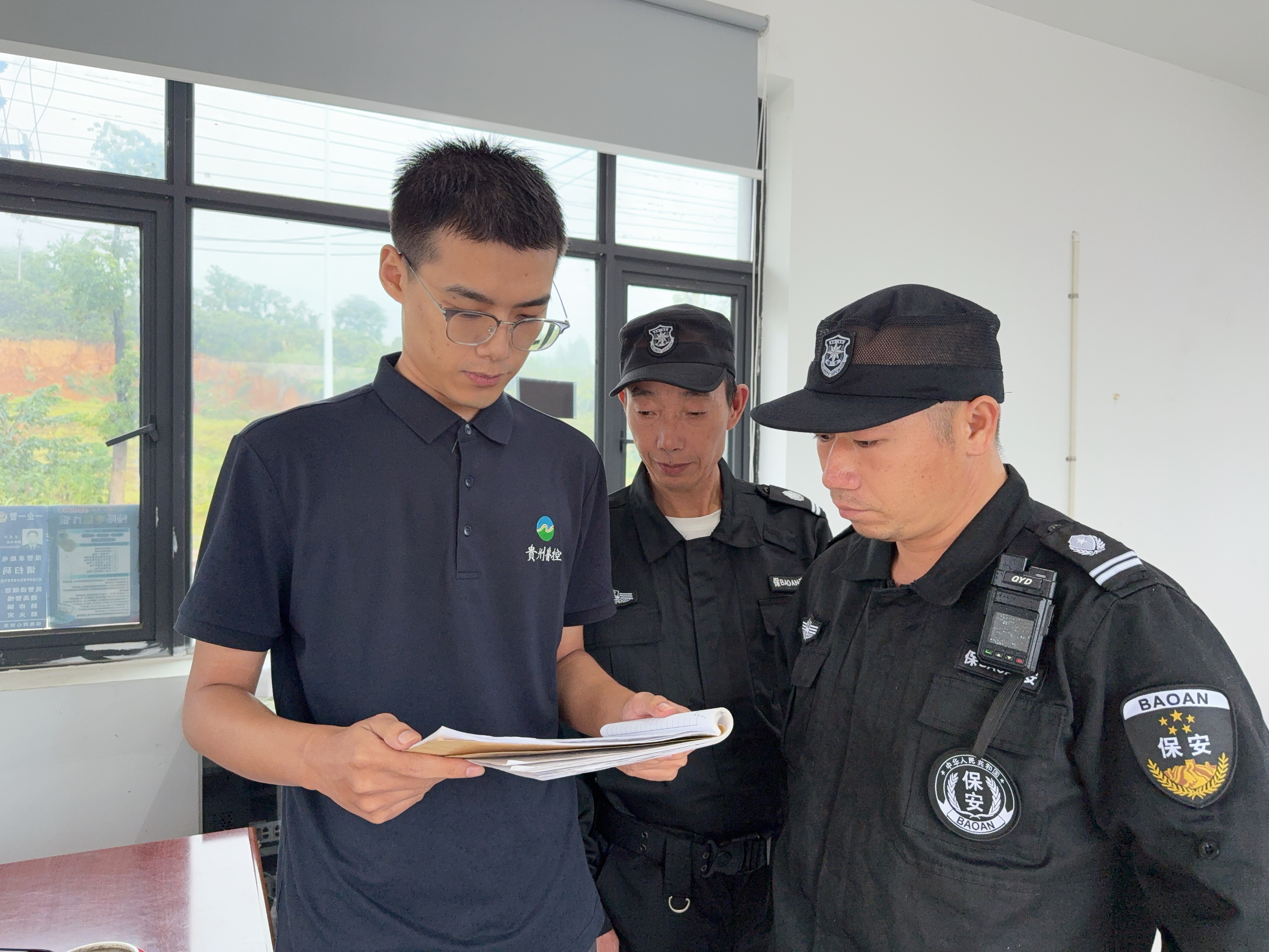 图为李鹏程检查进出车辆登记情况.jpg